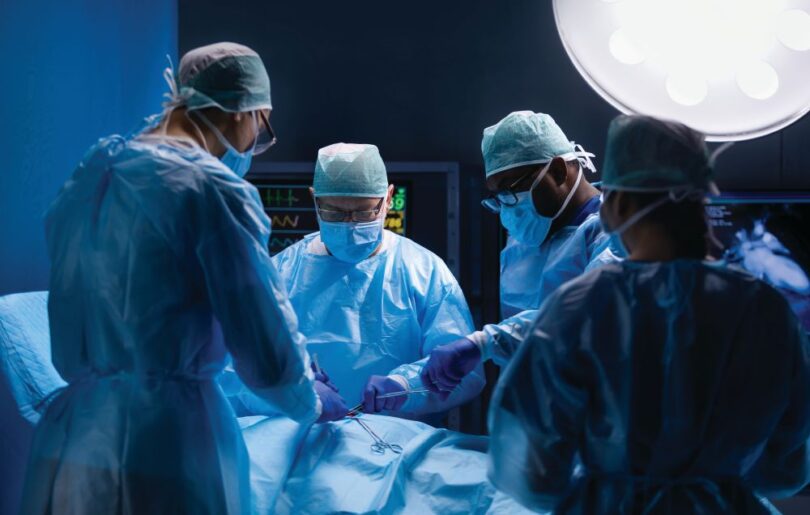 Surgeons performing complex procedure in an operating room, illustrating advanced surgical technology integration.