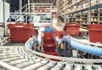 Automated conveyor system transporting crates inside PostNord TPL’s pharmaceutical distribution centre.