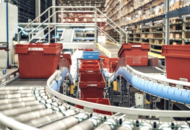 Automated conveyor system transporting crates inside PostNord TPL’s pharmaceutical distribution centre.