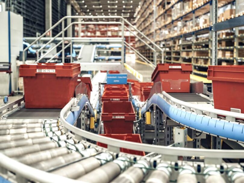 Automated conveyor system transporting crates inside PostNord TPL’s pharmaceutical distribution centre.