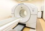 modern MRI machine in a hospital suite, with patient bed and scanner bore visible