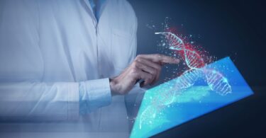 Scientists working with automated cell therapy manufacturing system