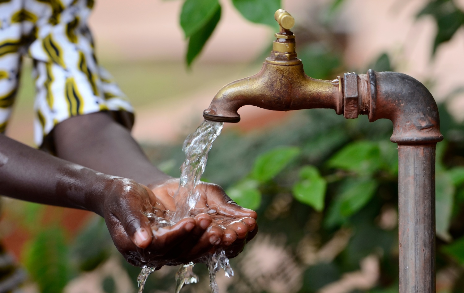 Hands collecting clean drinking water from an outdoor tap