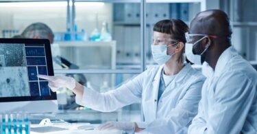 Life sciences professionals reviewing digital data within a modern biotechnology laboratory