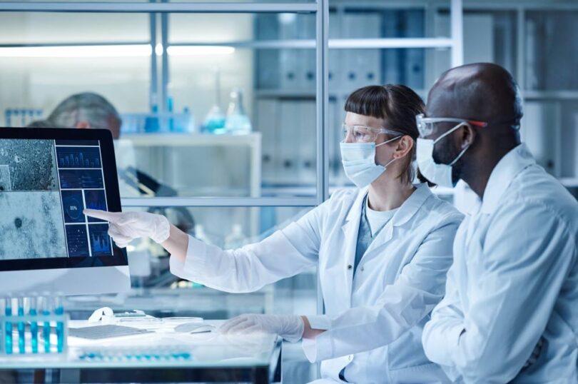 Life sciences professionals reviewing digital data within a modern biotechnology laboratory