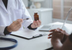 Stock photo of a doctor and a pharmacist discussing medicines, illustrating prescribing and dispensing of treatment.