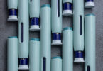 Close-up of several syringe-style self-injection pens arranged on a rustic gray kitchen counter.